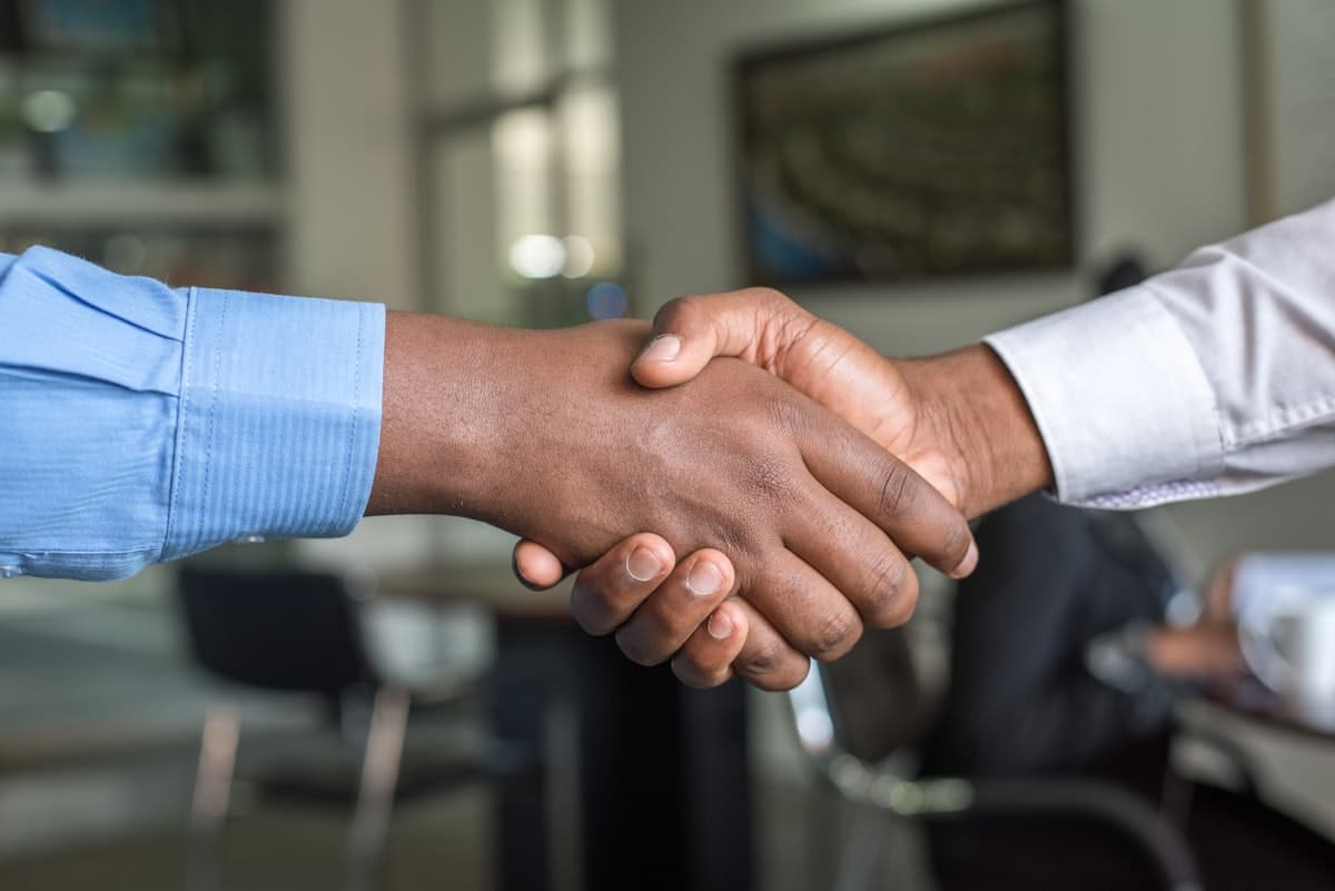Two professionals shaking hands in an office, representing Texas commercial law matters